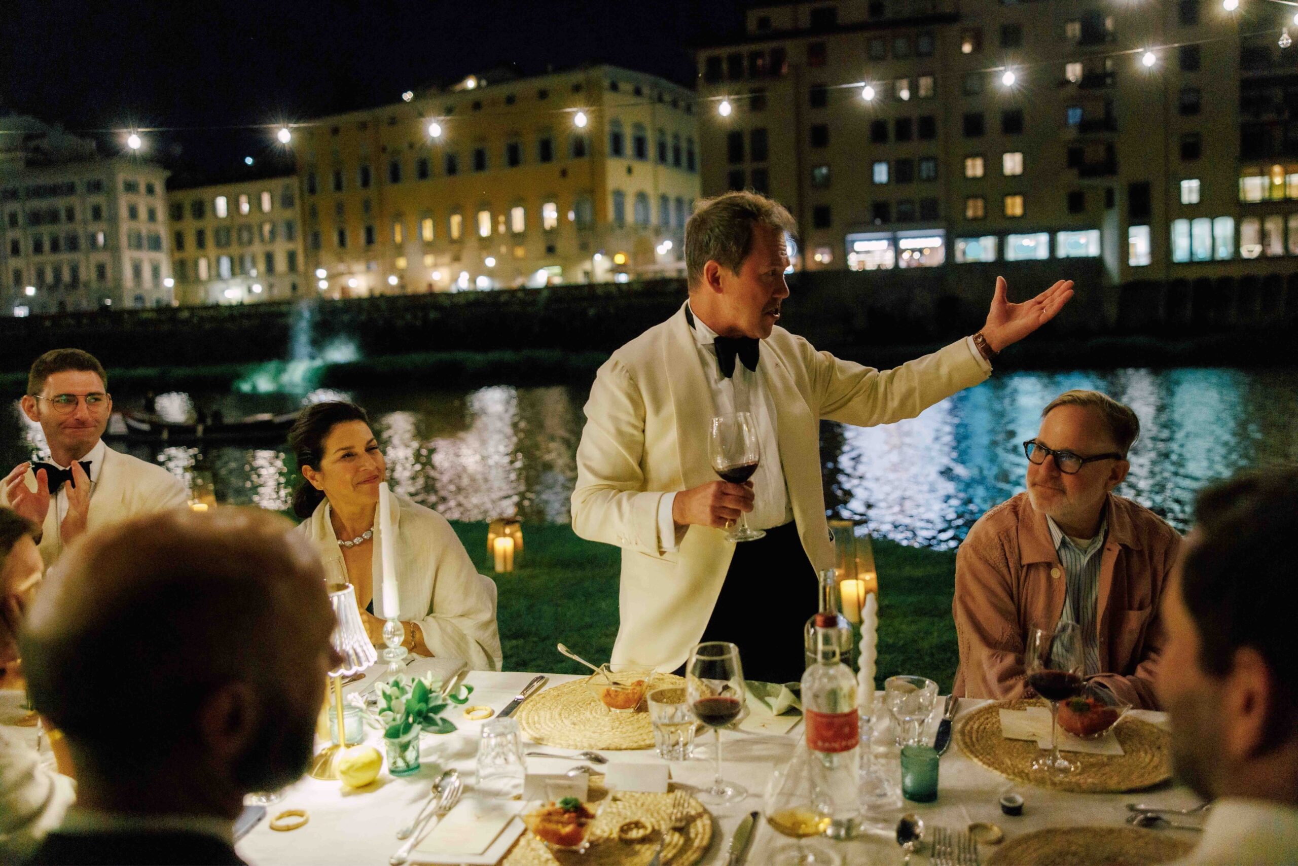 Angel Ramos and MAARNY family raising a toast at a private dining on the Arno River at the Florentine Rowing Club.