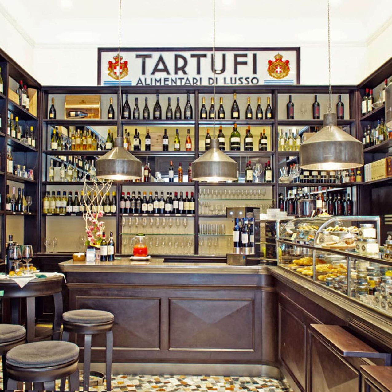 Luxury Italian wine bar with dark wood interiors, showcasing an extensive selection of fine wines and gourmet truffle delicacies at Tartufi Alimentari di Lusso in Florence.